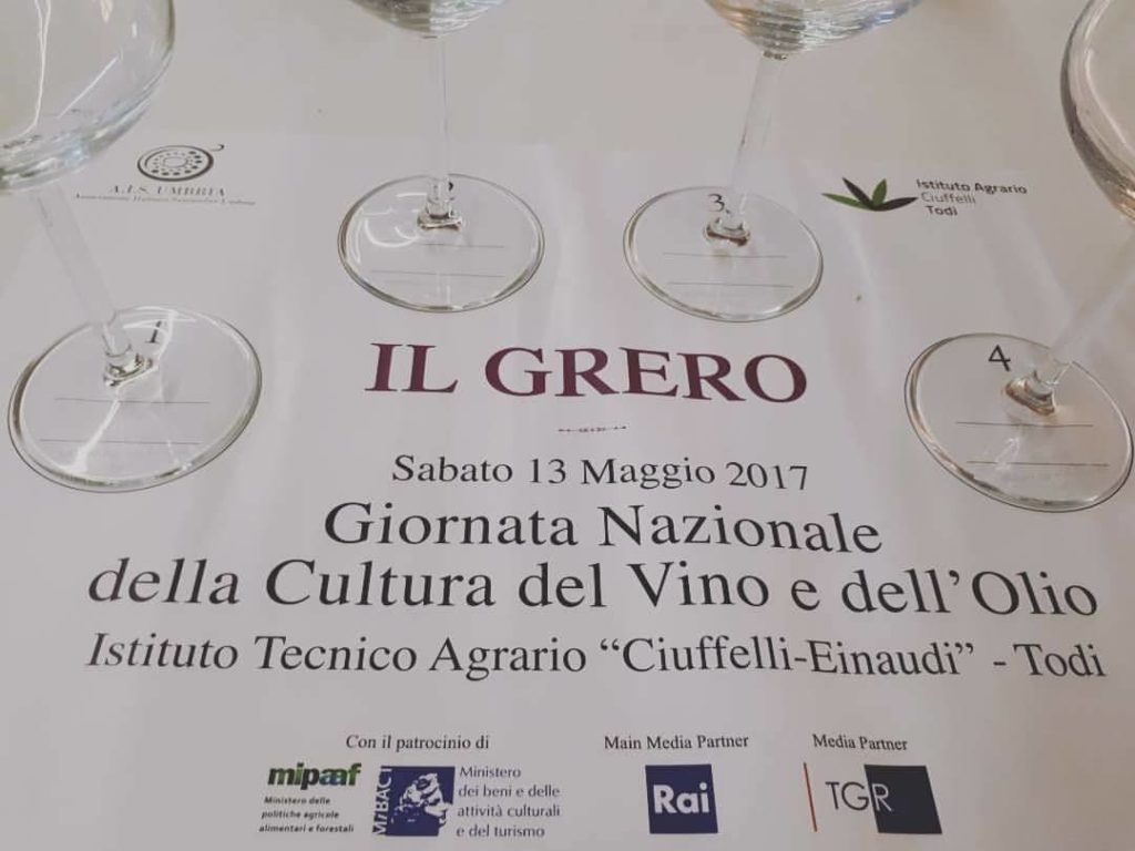 Tovaglietta di carta su cui sono appoggiati dei calici, creata per un evento dedicato al Grero organizzato presso l’Istituto Tecnico Agrario Ciuffelli-Einaudi di Todi in occasione della Giornata Nazionale per la Cultura del Vino e dell’Olio